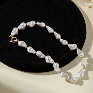 Detailed close-up of Baroque irregular pearl necklace with gold beads and OT toggle clasp