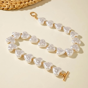 Close-up of heart-shaped pearls and gold OT toggle clasp on a baroque necklace