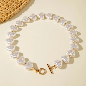 Detailed close-up of Baroque heart pearl necklace with golden spacer beads and OT toggle clasp