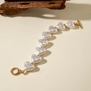 Detail of heart-shaped pearl bracelet with gold beads and a vintage toggle clasp