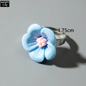 Gros plan d'une bague camélia bleue en résine avec anneau réglable argenté et dimensions