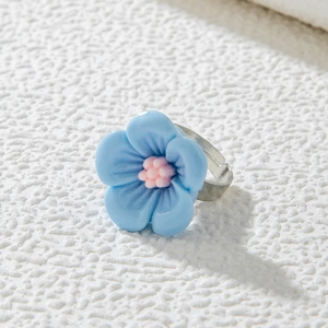 Détail d'une bague camélia bleue faite à la main avec anneau en métal réglable
