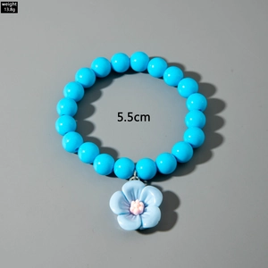 Bracelet en perles bleues avec pendentif camélia affichant le poids 13,8g et la taille 5,5cm