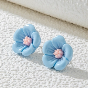Gros plan de boucles d'oreilles camélia bleu clair avec un centre rose doux pour femmes