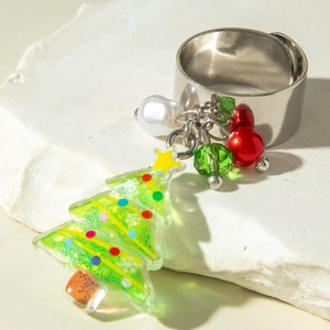 Macro detail of adjustable silver ring featuring resin Christmas tree and pearl charms