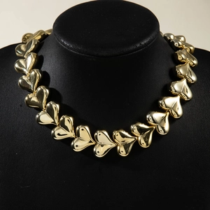 Macro view of polished gold chunky heart units on a necklace on a black bust