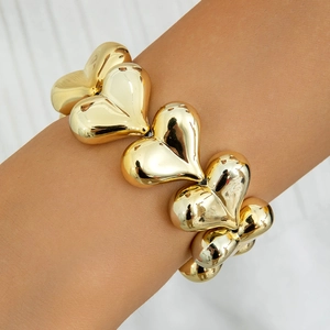 Close-up of a gold-plated chunky heart chain bracelet with a high-polished mirror finish