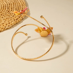 Detailansicht des goldenen Spiral-Armreifs mit 3D-Blumenakzenten im Sommer-Stil