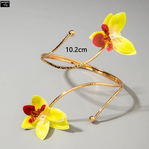 Detail eines 32g goldenen Spiral-Armreifs mit geprägtem Metall und bunten Orchideen