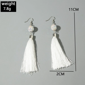 Détail de boucles d'oreilles longues à glands blancs avec clous en cristal et taille