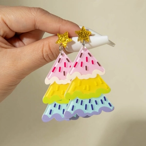 Détail de boucles d'oreilles sapin de Noël en acrylique avec étoile pailletée et rayures