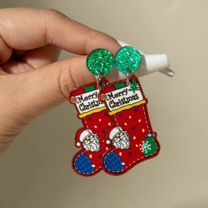 Détail de boucles d'oreilles chaussettes de Noël rouges en acrylique et paillettes
