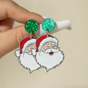 Gros plan de boucles d'oreilles Père Noël en acrylique avec paillettes vertes