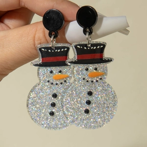 Détail de boucles d'oreilles bonhomme de neige en acrylique avec paillettes argentées