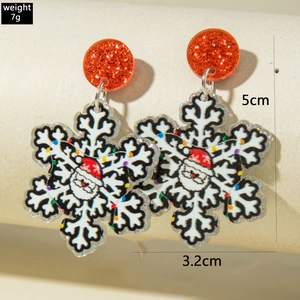 Vue détaillée de boucles d'oreilles flocon de neige en acrylique avec motif Père Noël