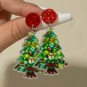 Détail de boucles d'oreilles sapin de Noël avec motif imprimé et paillettes festives