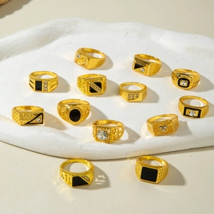 Macro detail of gold plated men's rings set with black stones and sparkling rhinestones