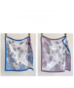 Détail d'un foulard en soie réversible avec motif floral bleu et violet doux