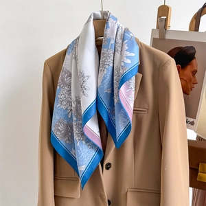 Élégant foulard en soie bleu ciel à fleurs porté avec un blazer sur un cintre