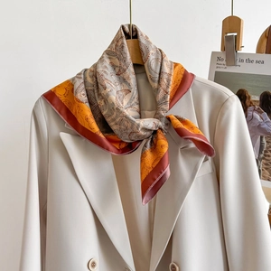 Classic paisley pattern square silk scarf styled on a cream blazer for a chic look
