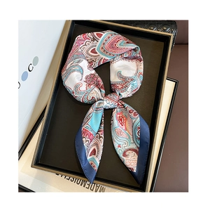 Detail of luxury paisley print silk scarf tied in a bow on a stylish display tray