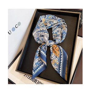 Macro detail of paisley pattern silk scarf with smooth satin texture and rolled edges