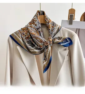 Detail of paisley silk scarf with caramel and blue tones on a beige blazer collar