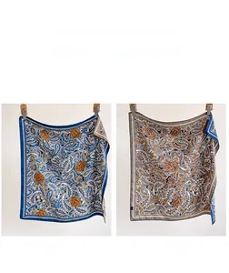 Detail view of double-sided paisley silk scarf showing navy blue and brown pattern contrast