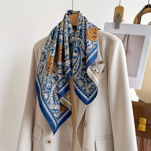 Blue paisley square silk scarf styled with beige blazer and leather handbag accessory