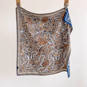 Elegant paisley silk scarf with brown tones and a blue border shown in full view