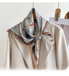 Detail of grey twill silk scarf with equestrian horse print styled on a beige suit collar