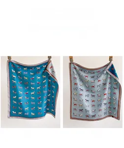Detail of double-sided silk scarf showing teal and grey-blue sides with horse patterns