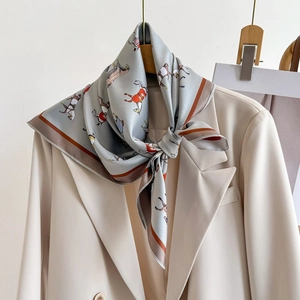 Elegant horse print silk scarf for women styled on a cream blazer with vintage equestrian pattern