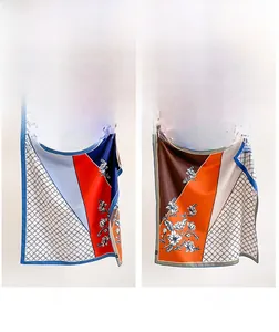 Détail d'un foulard en soie double face avec motifs floraux et géométriques colorés