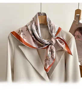 Detail of a 70cm twill silk scarf with vibrant floral print on a beige blazer