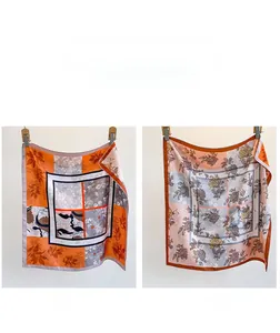 Detail of double-sided twill silk scarf showing orange floral and pink-blue contrast patterns