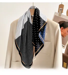 Close-up of black and white polka dot silk scarf draped over a beige blazer