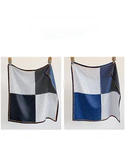 Detailed close-up of double-sided polka dot silk scarf with contrast orange rolled edges