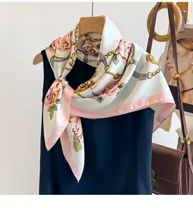 Détail d'un foulard en soie aux motifs de fleurs et chaînes sur une robe bleue