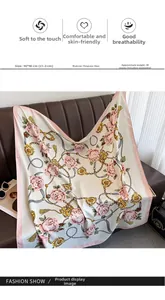 Détail de fleurs de camélia et chaînes dorées sur foulard carré rose 90x90 cm