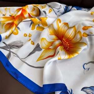 Foulard en soie à imprimé floral jaune et orange sur satin blanc avec bordure bleue
