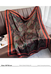 Detail of 90x90cm paisley silk scarf with vintage red and green pattern on leather sofa