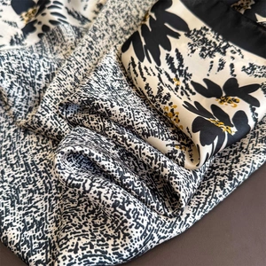Fashionable silk scarf with black white floral print and elegant draped texture design