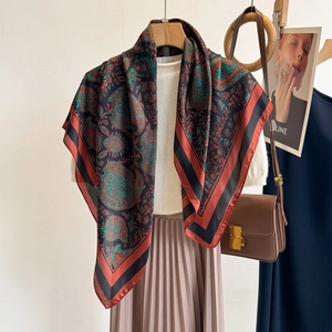 Classic paisley print large square shawl draped over a knit top for sun protection