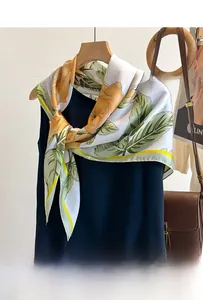 Vue détaillée d'un foulard en soie à imprimé roses jaunes noué sur un chemisier