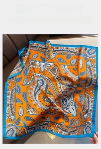 Detailed macro of orange paisley silk square scarf with contrasting blue hem