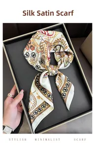 Detail of elegant satin square scarf with paisley pattern in a luxury tray