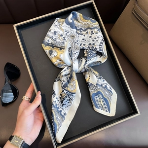Elegant paisley square scarf tied in a bow on a luxury display tray with fashion accessories