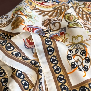 Close-up of paisley pattern silk scarf with ornate baroque motifs and hemmed edges