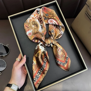 Vintage paisley print silk-like scarf in earthy tones displayed on a black tray